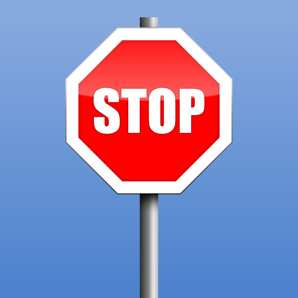 Red stop sign with bold white letters against a blue background, indicating the need to halt, commonly used in traffic control.