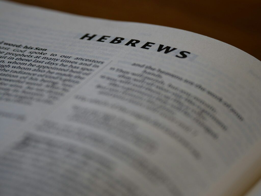 The bible page reads the book of hebrews